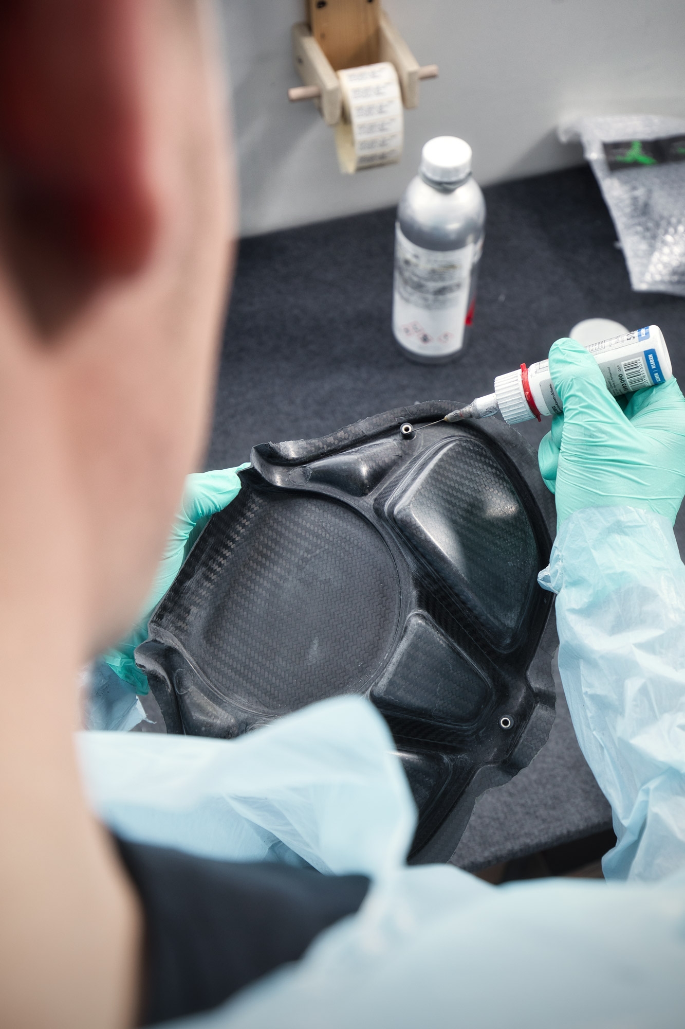 Mitarbeiter spritzt Flüssigkeit in Carbonteil